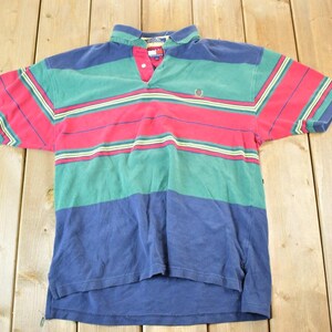 May include: A striped polo shirt with red, green, blue and yellow stripes. The shirt has a button-down collar and a small logo on the chest.