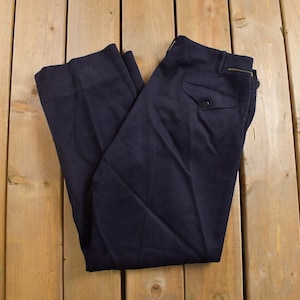 Puede incluir: Un pantalón de lana azul oscuro con un solo bolsillo con botón en la parte posterior.