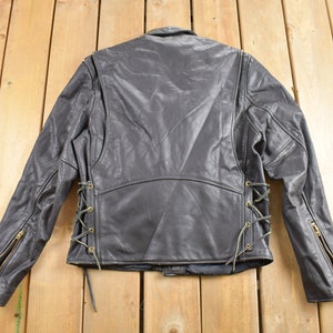 May include: Black leather jacket with a lace-up detail on the sides. The jacket has a zipper on the front and on the sleeves.