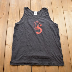 Puede incluir: Un tanque negro con un logotipo "O.S." rojo impreso en la parte delantera.