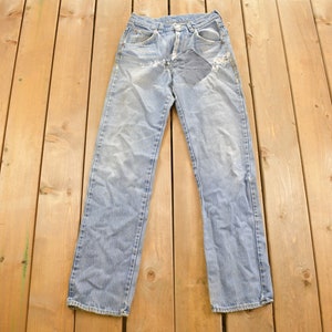 May include: A pair of light blue denim jeans with a distressed patch on the right knee.