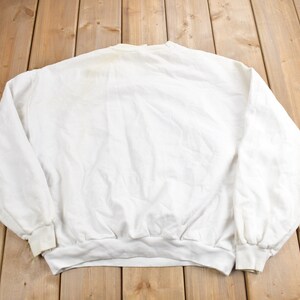 K&ouml;nnte beinhalten: Wei&szlig;er Langarm-Pullover mit Rundhalsausschnitt.