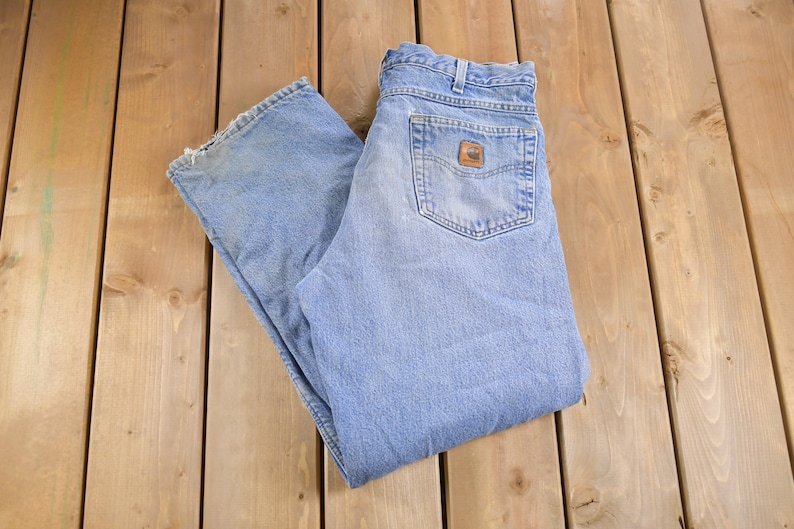 May include: A pair of light blue denim jeans with a brown leather patch on the back pocket.