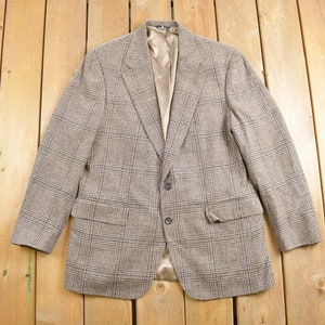 May include: A brown and black checked blazer with a single button fastening.