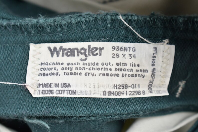 以下が含まれることがあります： 緑色の Wrangler ブランドのデニムラベルで、白いテキストが書かれています。ラベルには、サイズ 28 x 34、スタイル番号 936NTG、および洗濯方法が記載されています。洗濯方法: 裏返して洗濯してください。同系色と一緒に洗ってください。漂白剤を使用する場合は、塩素系漂白剤は使用しないでください。必要に応じて、タンブラー乾燥してください。乾燥後、すぐに取り出して下さい。ラベルには、「Made in USA」と「100% コットン」の文字も記載されています。