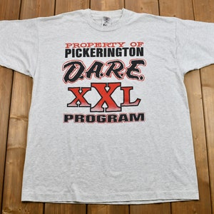 May include: Gray t-shirt with red and black text that reads "Property of Pickerington D.A.R.E. XXL Program".