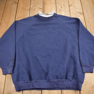 May include: A navy blue sweatshirt with a white ribbed collar.