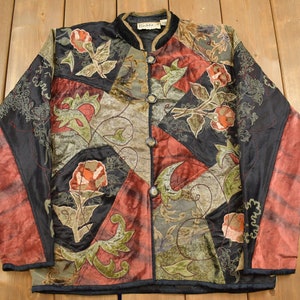 May include: A black, red, and green quilted jacket with floral embroidery and a button closure. The jacket has a mandarin collar and a patchwork design.