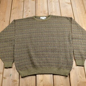 Könnte beinhalten: Ein grüner, brauner und blauer Pullover mit Rundhalsausschnitt.