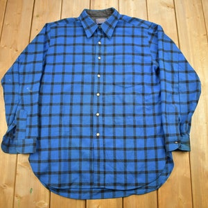 May include: A blue and black plaid long-sleeve shirt with a button-down collar.