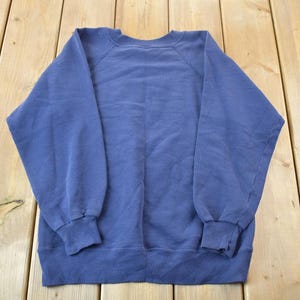 May include: A solid blue sweatshirt with a crew neck and long sleeves.