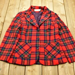 May include: A red, green, and blue plaid blazer with two pockets and three buttons.