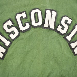 May include: Green sweatshirt with a white felt "WISCONSIN" patch on the back.
