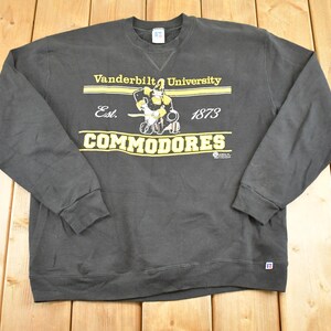 May include: A dark gray sweatshirt with the text "Vanderbilt University COMMODORES" in yellow. The sweatshirt has long sleeves and a crew neck. The graphic includes a Commodore mascot.