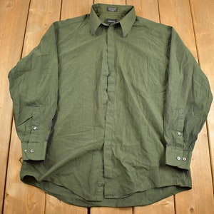 May include: A long-sleeved, green button-down shirt with a collared neckline. The shirt has a subtle texture and is made of a lightweight fabric.