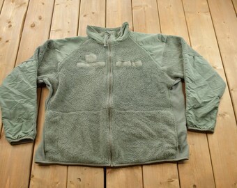 May include: A green fleece jacket with a zipper closure and two pockets. The jacket has a textured, fuzzy surface.