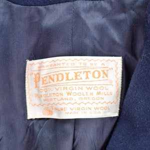 Pu&ograve; includere: Un'etichetta bianca con il testo "WARRANTED TO BE A PENDLETON" in lettere arancioni. L'etichetta riporta anche "100% VIRGIN WOOL PENDLETON WOOLEN MILLS PORTLAND, OREGON PURE VIRGIN WOOL MADE IN USA".