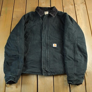 Puede incluir: Chaqueta de trabajo verde oscuro con cuello de pana y cierre de botones. La chaqueta tiene dos bolsillos delanteros grandes y un peque&ntilde;o parche cuadrado con el logo. La chaqueta est&aacute; hecha de un material duradero.