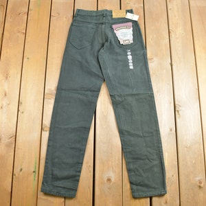 May include: A pair of dark green relaxed fit jeans with a Lee label on the back pocket.