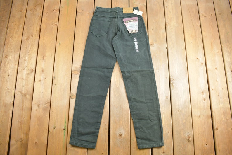 May include: A pair of dark green relaxed fit jeans with a Lee label on the back pocket.
