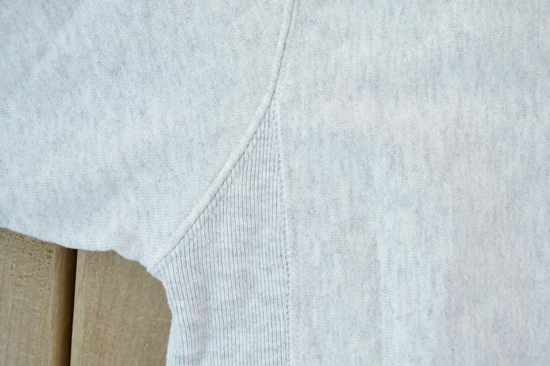 Puede incluir: Primer plano de una sudadera gris con textura acanalada. La tela es suave y c&oacute;moda.