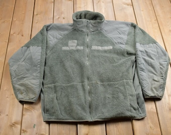May include: A green fleece jacket with a zipper closure and two pockets. The jacket has a stand-up collar and is made of a soft, warm material.
