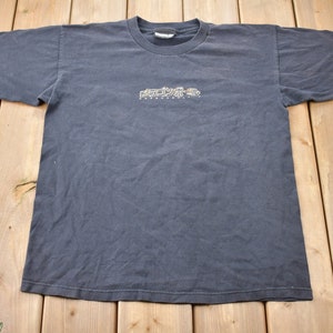 May include: A dark gray t-shirt with the text "RECKLESS" in a stylized font and the words "skateboarding" underneath.
