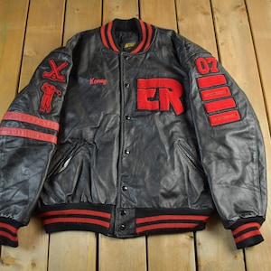 May include: Black leather jacket with red detailing. Features the name "Kenny" in red script, "ER" in large red letters, and the number "07" on the sleeve. Includes red and black striped cuffs and collar.