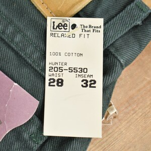 Może przedstawiać: Biała metka z czarnym tekstem, na kt&oacute;rej widnieje napis "Lee The Brand That Fits Relaxed Fit 100% Bawełna Hunter 205-5530 Talia 28 Długość nogawki wewnętrzna 32"