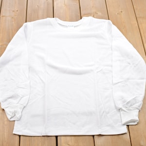 Op de afbeelding: Een effen wit longsleeve t-shirt met een ronde hals.