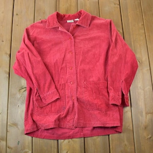 May include: A long-sleeved, red corduroy shirt with a button-up front and two pockets.
