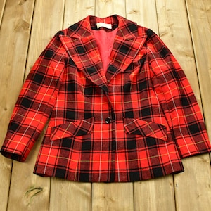 May include: A red, black, and yellow plaid blazer with a double-breasted closure and two flap pockets.