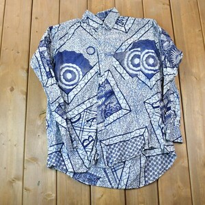 Peut inclure: Une chemise boutonnée à manches longues blanche avec un motif géométrique bleu et blanc. Le motif présente des cercles, des carrés et d'autres formes abstraites.