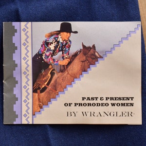 May include: A brochure with a woman in a cowboy hat riding a horse. The brochure is titled "Past & Present of ProRodeo Women by Wrangler."