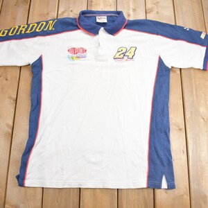 May include: White polo shirt with blue and red trim. The shirt has "GORDON" on the left sleeve, a "DUPONT" logo on the chest, and "24" on the right side.