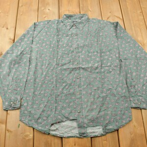 May include: A long-sleeved button-down shirt with a paisley pattern in shades of green and pink.
