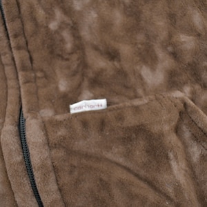 May include: A brown fleece jacket with a zipper closure and a Carhartt label on the pocket.