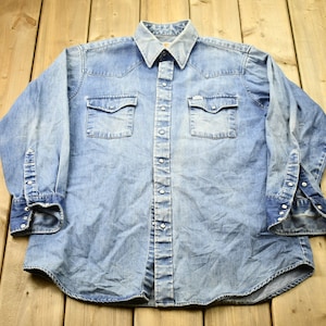 Camisa de jean con remera abajo sale