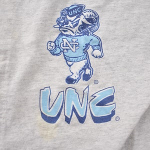 May include: A gray sweatshirt with a blue and white graphic of a ram mascot with the text "UNC" above and below the mascot.
