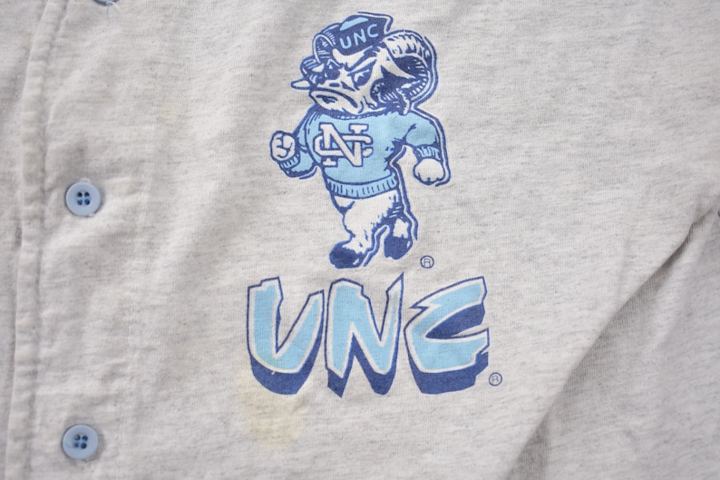 May include: A gray sweatshirt with a blue and white graphic of a ram mascot with the text "UNC" above and below the mascot.