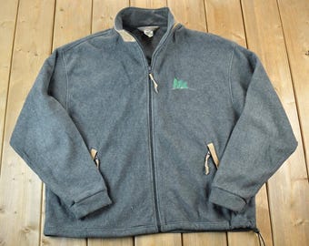 May include: A gray fleece jacket with a full zipper closure, featuring a stand-up collar and two front pockets. The jacket has a small green tree logo on the chest and tan accents. The jacket is approximately 28 inches long.