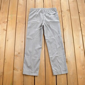 May include: A pair of grey casual trousers with an elastic waistband and a single back pocket.
