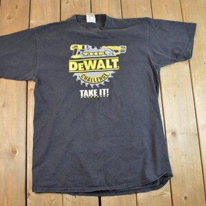 May include: A black t-shirt featuring a yellow and black Dewalt logo. The logo depicts a power tool and the text "Dewalt Challenge Take It!"
