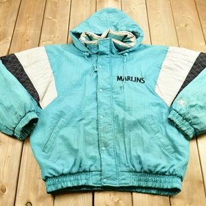 May include: A teal blue, white, and black reversible jacket with a hood and the word "Marlins" embroidered on the front.