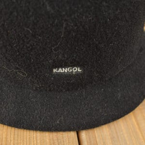 May include: Black felt bucket hat with a Kangol logo.