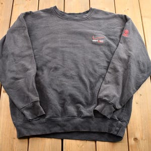 May include: A dark gray sweatshirt with a red and white logo that says "vert.com" on the front.