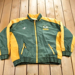 May include: Green and yellow windbreaker jacket with the Green Bay Packers logo and the letter "G" on the front. The jacket has a zipper closure and two pockets.
