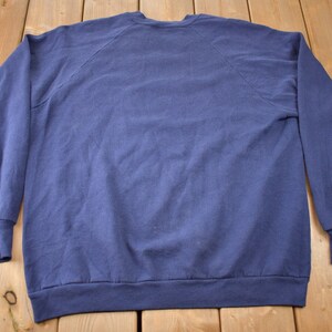 K&ouml;nnte beinhalten: Ein marineblauer Pullover mit langen &Auml;rmeln und einem Rundhalsausschnitt.