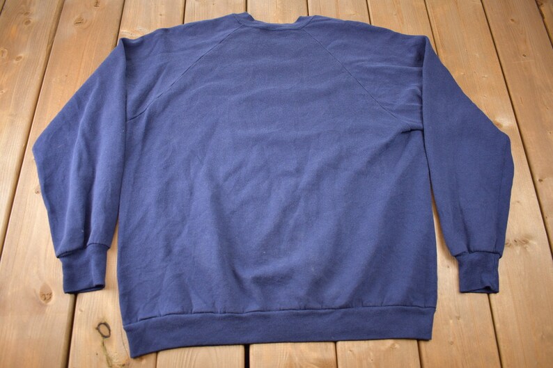 K&ouml;nnte beinhalten: Ein marineblauer Pullover mit langen &Auml;rmeln und einem Rundhalsausschnitt.
