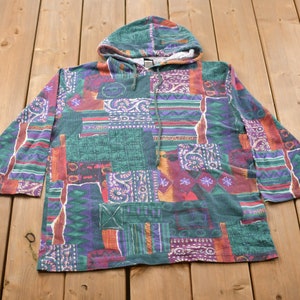 Op de afbeelding: Een groene, paarse, oranje en rode gepatroneerde hoodie met een trekkoord.